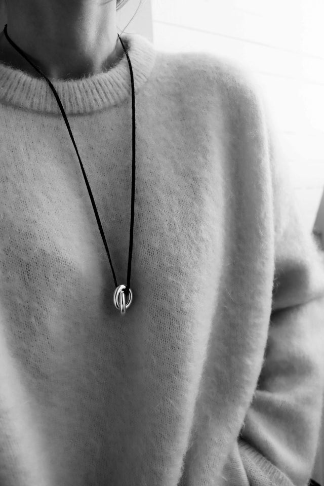Tjej som bär ett choker halsband med svart läderband och två tjocka länkar. 