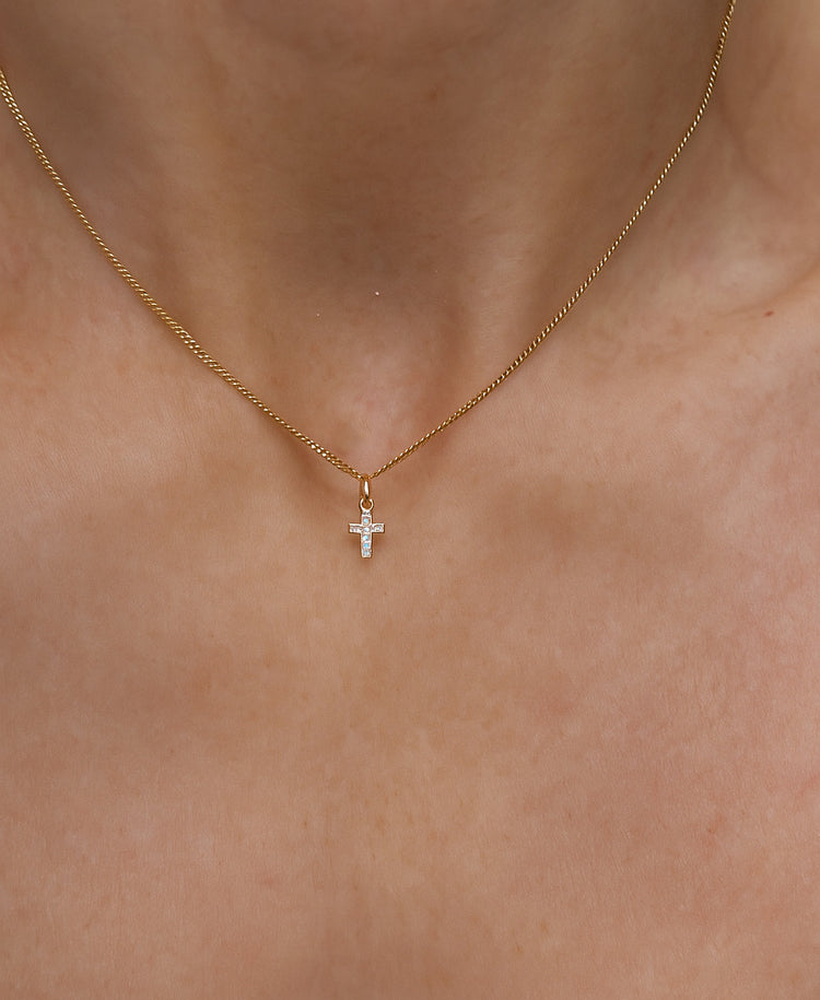 Halsband med ett litet diamantkors i guld. 