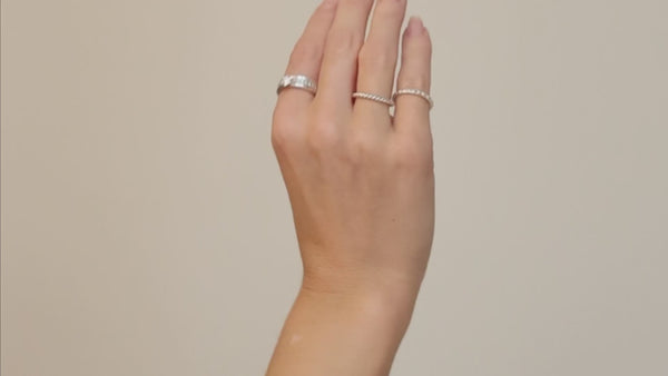 Video på en tjej som provar silverringar i kombination med diamantringar. Smala ringar som bärs tillsammans på olika fingrar. 