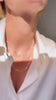 Tjej som bär ett kort diamanthalsband kombinerat med tunna kedjor i lager på lager stil. 