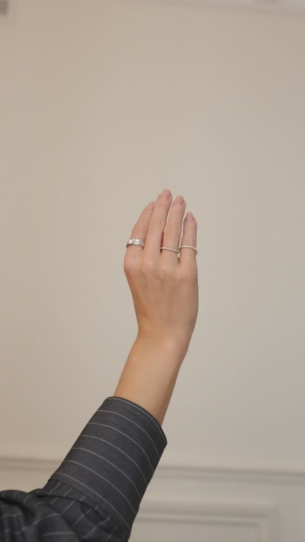 Tjej som stylar silverringar och diamantringar. Hon bär flera ringar utspridda på olika fingrar.  