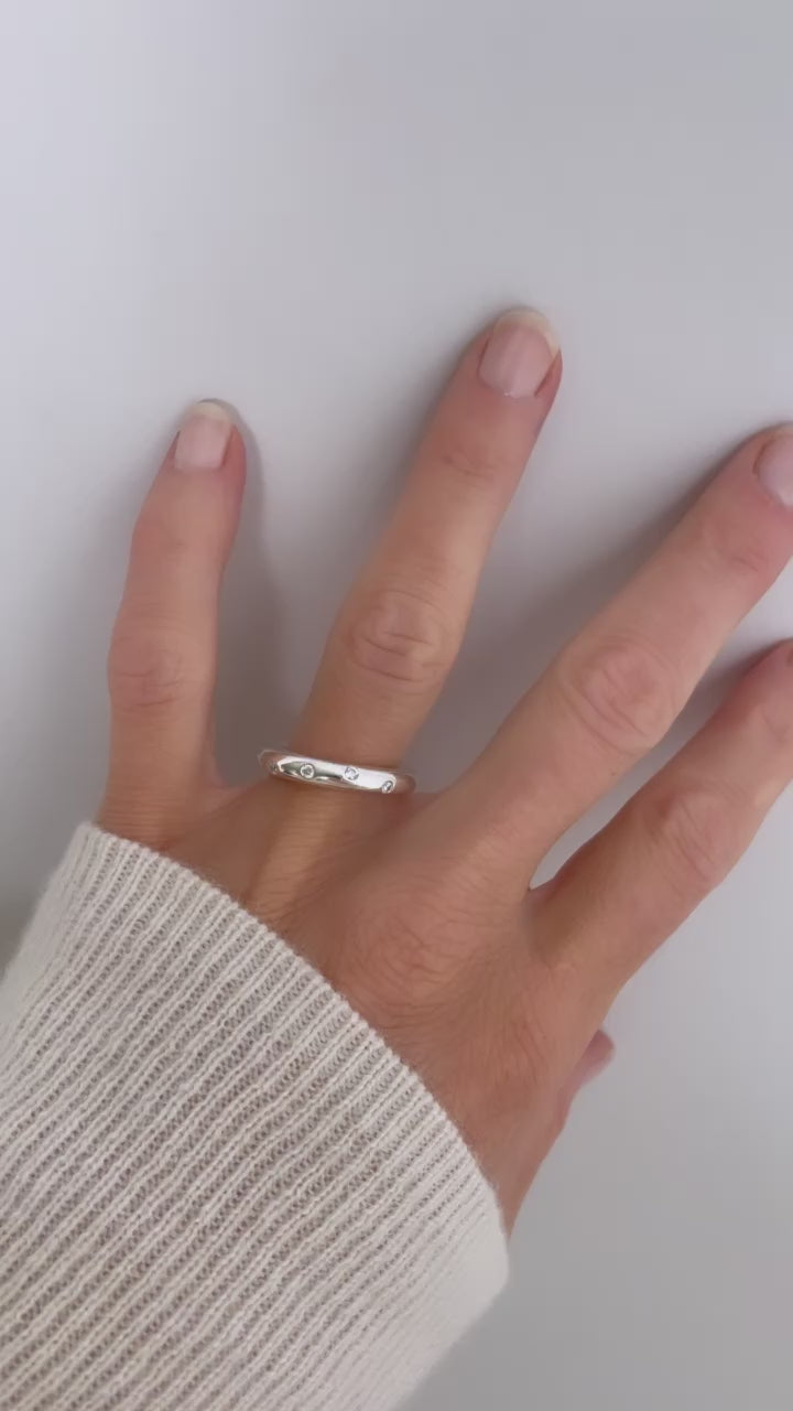 Tjej som bär en tjock silverring med flera diamanter