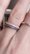 en svart och en vit diamantring i kombination på ett finger. 