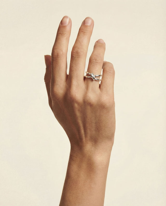 Silverring med en enkel knut på kvinnlig hand. 