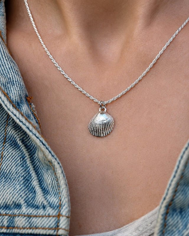 Tjej som bär ett halsband med silversnäcka i kedja. 
