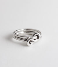 Silverring med dubbla ringar som förenas i en evighetsknut