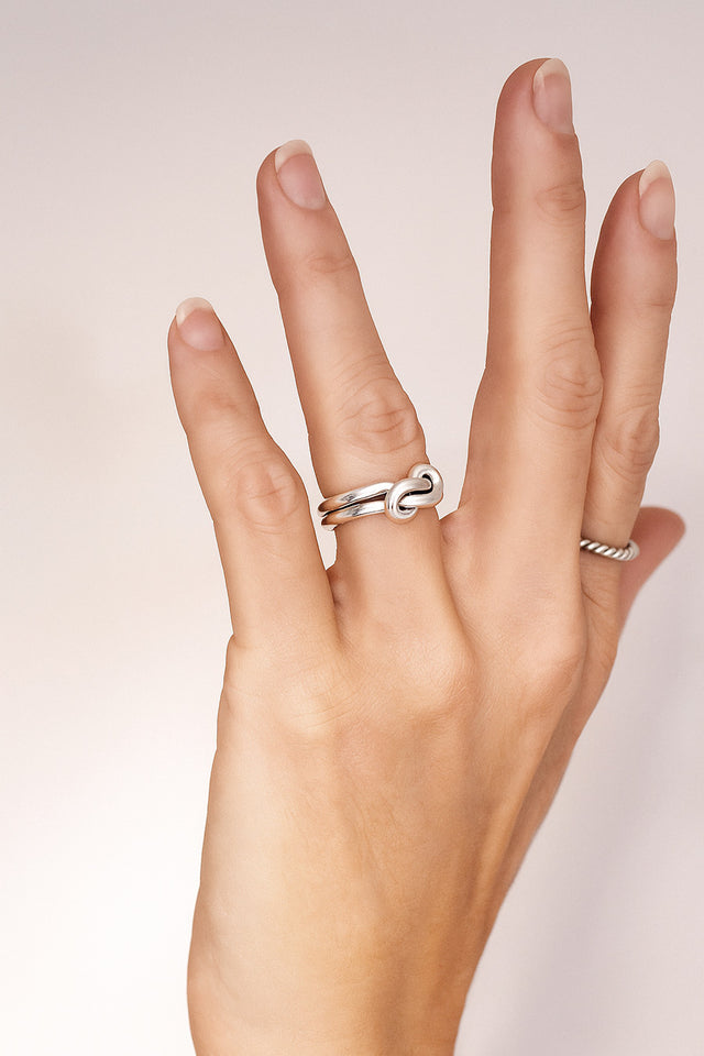 silverring med dubbla ringar som förenas i en evighetsknut. 
