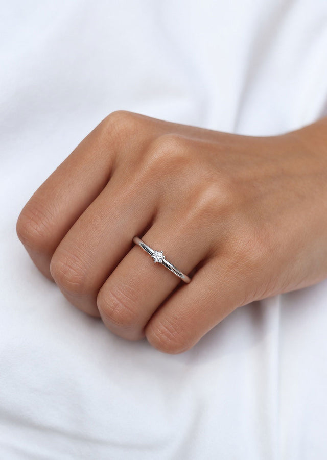 Tjej som bär en silverring med 0,10 ct diamant. 