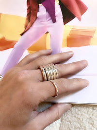 Bred ring stack med fyra tjocka silverringar som bärs på samma finger. 