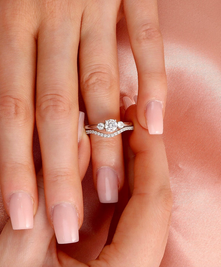 Ring set med vigselringar. Alliansring med böjd form och ring med tre diamanter